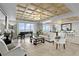 Elegant living room featuring a coffered ceiling, tile flooring, and ocean views at 601 Longboat Club Rd # 504S, Longboat Key, FL 34228