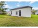 Exterior view of a well-maintained, white stucco home with a lush green lawn and a black door at 6140 Bobby Jones Ct, Palmetto, FL 34221