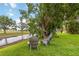 Serene backyard with a small stream and a shady tree, featuring two comfortable gray Adirondack chairs at 6140 Bobby Jones Ct, Palmetto, FL 34221