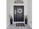 Elegant front door with wreath, welcome mat, and potted plants creating a warm entrance at 6140 Bobby Jones Ct, Palmetto, FL 34221
