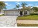 Charming home featuring lush landscaping, well-manicured lawn, and a spacious three-car garage at 6140 Bobby Jones Ct, Palmetto, FL 34221