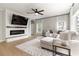 Cozy living room with a fireplace, large sectional sofa, and lots of natural light at 6140 Bobby Jones Ct, Palmetto, FL 34221