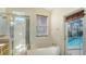 Well-lit bathroom showcasing a tub with a door that leads to the outdoor pool area at 6213 Willet Ct, Lakewood Ranch, FL 34202