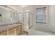 Bright bathroom features a glass-enclosed shower, soaking tub, and a large window for natural light at 6213 Willet Ct, Lakewood Ranch, FL 34202
