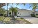 Charming single-story home featuring a well-manicured lawn, palm trees, and a two-car garage at 6213 Willet Ct, Lakewood Ranch, FL 34202
