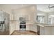 Bright kitchen with stainless steel appliances and white cabinetry adjacent to the living area at 6213 Willet Ct, Lakewood Ranch, FL 34202