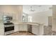 Kitchen with white cabinetry, stainless steel appliances, and a breakfast bar overlooking the living room at 6213 Willet Ct, Lakewood Ranch, FL 34202
