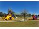 Bright and colorful playground area with slides, swings, and climbing structures under a clear blue sky at 6213 Willet Ct, Lakewood Ranch, FL 34202