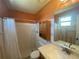 This bathroom features a shower/tub combo, tiled walls, and granite countertops at 6618 Kenwood Dr, North Port, FL 34287