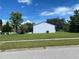 Back view of home, featuring a well-manicured lawn and mature trees at 6618 Kenwood Dr, North Port, FL 34287