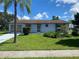 Charming single-story home featuring a well-maintained lawn and a mature palm tree in the front yard at 6618 Kenwood Dr, North Port, FL 34287