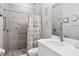 Modern bathroom with tiled walk-in shower, white vanity, and decorative accents at 6636 35Th E Ct, Sarasota, FL 34243