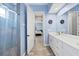 Well-lit bathroom with double vanity, tiled floors, and a glass-enclosed shower at 6636 35Th E Ct, Sarasota, FL 34243