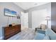 Stylish bedroom with a sleek dresser, closet, and light blue modern sofa at 6636 35Th E Ct, Sarasota, FL 34243