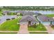 A house with a lush green lawn, brick driveway, two-car garage, and a serene lake in the background at 6636 35Th E Ct, Sarasota, FL 34243