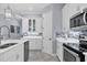 Bright kitchen with stainless steel appliances, white cabinets, mosaic backsplash, and modern lighting at 6636 35Th E Ct, Sarasota, FL 34243