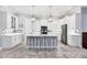 Modern kitchen boasts white cabinets, an island with bar seating, and stainless steel appliances for a chef's dream at 6636 35Th E Ct, Sarasota, FL 34243
