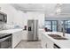 Spacious white kitchen with stainless steel refrigerator, mosaic backsplash and marble countertop island at 6636 35Th E Ct, Sarasota, FL 34243