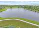 Picturesque aerial view of a pond and walking path amidst green fields, offering tranquility and natural beauty at 6636 35Th E Ct, Sarasota, FL 34243
