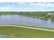 Expansive pond view with a lakeside walking path, green fields, and a clear sky backdrop at 6636 35Th E Ct, Sarasota, FL 34243