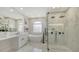 Bright bathroom features a soaking tub, glass-enclosed shower, and double vanity with marble countertops at 6641 Saint James Xing, University Park, FL 34201