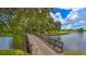 Picturesque wooden bridge over a calm lake, surrounded by green trees and landscaping at 6641 Saint James Xing, University Park, FL 34201