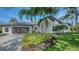 Beautiful home showcasing a well-maintained lawn, palm trees, a tile roof, and a large driveway at 6641 Saint James Xing, University Park, FL 34201