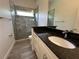 Updated bathroom with a walk-in shower featuring stone tiles, granite countertop and a single vanity at 6839 Turnberry Isle Ct, Lakewood Ranch, FL 34202
