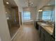 Elegant bathroom boasts a chandelier, standalone tub, walk-in shower, and double vanity with granite countertops at 6839 Turnberry Isle Ct, Lakewood Ranch, FL 34202