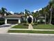Beautiful single-story home with a tile roof, a two-car garage, and lush tropical landscaping at 6839 Turnberry Isle Ct, Lakewood Ranch, FL 34202