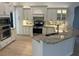 Modern kitchen with white cabinetry, granite countertops, stainless steel appliances, and tile backsplash at 6839 Turnberry Isle Ct, Lakewood Ranch, FL 34202