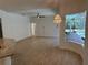 Spacious living room offering wood-look tile flooring, a ceiling fan, and views of the outdoor pool area at 6839 Turnberry Isle Ct, Lakewood Ranch, FL 34202