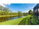 Scenic backyard view with a lush green lawn and a serene lake at 7081 Grassland Ct, Sarasota, FL 34241