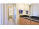Bright bathroom featuring a granite countertop, wood cabinets, and a view into the adjacent bedroom at 7081 Grassland Ct, Sarasota, FL 34241