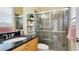 Bathroom with granite counters, wood cabinetry, and tiled walk-in shower at 7081 Grassland Ct, Sarasota, FL 34241