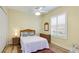 Bedroom with yellow walls, wood floors, queen bed, dresser, ceiling fan, and window with plantation shutters at 7081 Grassland Ct, Sarasota, FL 34241