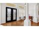 Elegant foyer featuring a beautiful glass front door, gleaming hardwood floors, and sophisticated architectural details at 7081 Grassland Ct, Sarasota, FL 34241
