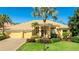 Beautiful single-story home boasting a well-manicured lawn, a light yellow exterior, and a terracotta-colored tile roof at 7081 Grassland Ct, Sarasota, FL 34241