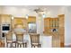 Kitchen with custom wood cabinetry, modern appliances, granite countertops, breakfast bar seating, and pendant lighting at 7081 Grassland Ct, Sarasota, FL 34241