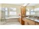 Main bathroom featuring a soaking tub, granite countertop with double sinks, and glass shower at 7081 Grassland Ct, Sarasota, FL 34241