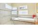Main bathroom with tub, large glass shower, granite countertop, and block windows for natural light and privacy at 7081 Grassland Ct, Sarasota, FL 34241