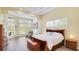 Large main bedroom featuring white bedding, custom trim work, wood floors, and natural light from the windows at 7081 Grassland Ct, Sarasota, FL 34241