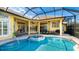 An inviting screened-in pool area with a spa and lounge chairs, perfect for outdoor relaxation and entertainment at 7081 Grassland Ct, Sarasota, FL 34241