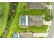 Aerial view of a backyard oasis with a screened-in pool, lush landscaping, and a tranquil pond at 7410 61 E St, Palmetto, FL 34221