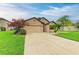 Charming one-story home boasts a well-manicured lawn, mature landscaping, and attached two-car garage at 7410 61 E St, Palmetto, FL 34221
