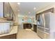 Modern kitchen with stainless steel appliances, granite countertops, and an open view to the living area at 7410 61 E St, Palmetto, FL 34221