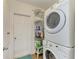 Well-equipped laundry room with stacked washer and dryer and storage shelving at 7410 61 E St, Palmetto, FL 34221