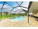 Spacious screened-in pool area with a brick deck, surrounded by lush landscaping and other homes at 7410 61 E St, Palmetto, FL 34221