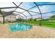 Inviting pool in a screened enclosure, set against a backdrop of lush greenery and neighboring homes at 7410 61 E St, Palmetto, FL 34221