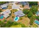 An aerial view of a single Gathering house showcasing the private in-ground pool, mature trees, and community layout at 7615 17Th W Ave, Bradenton, FL 34209